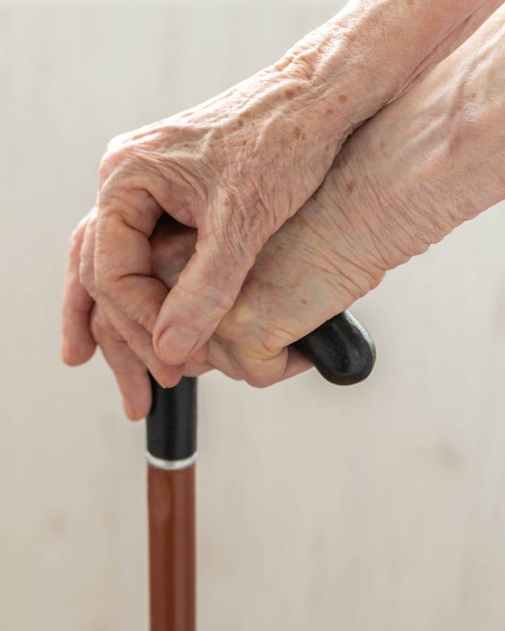 Older person holding walking cane