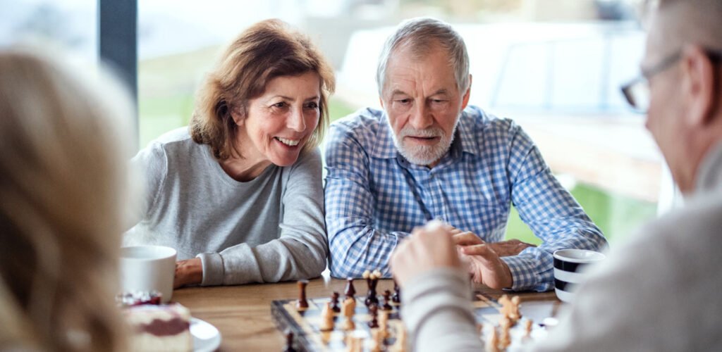 Two mature couples playing chess