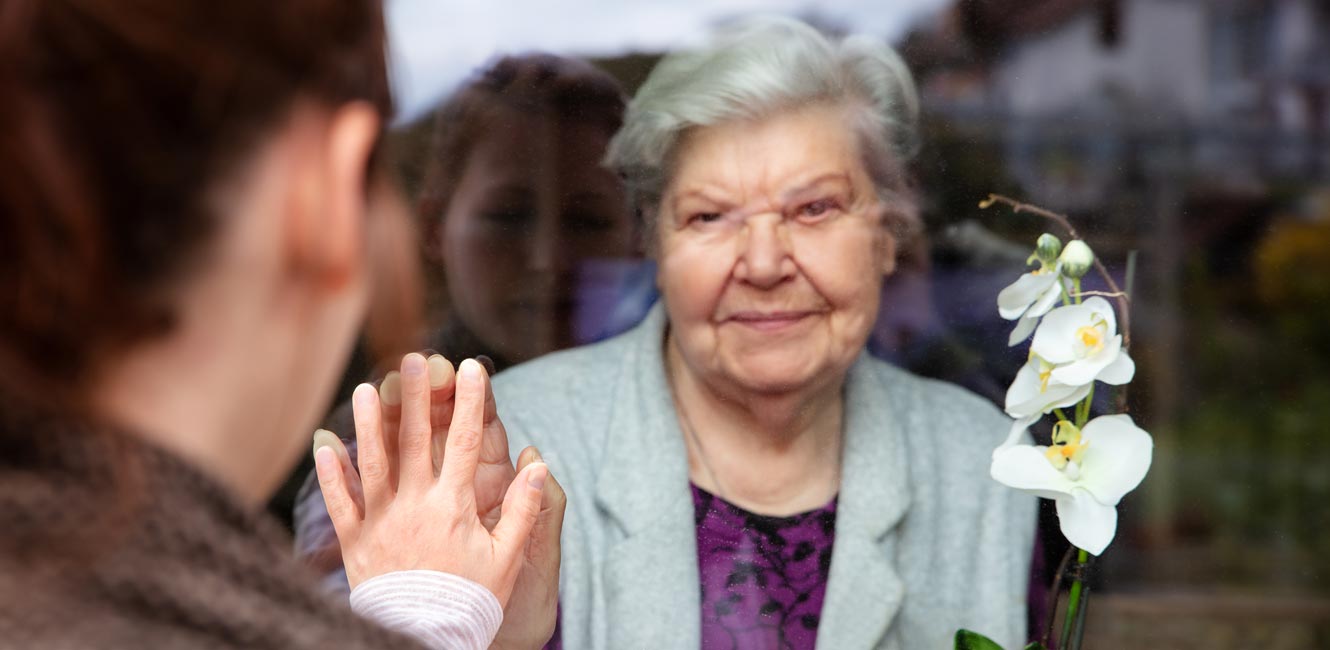 grandma and grandchild on a window plane social distancing